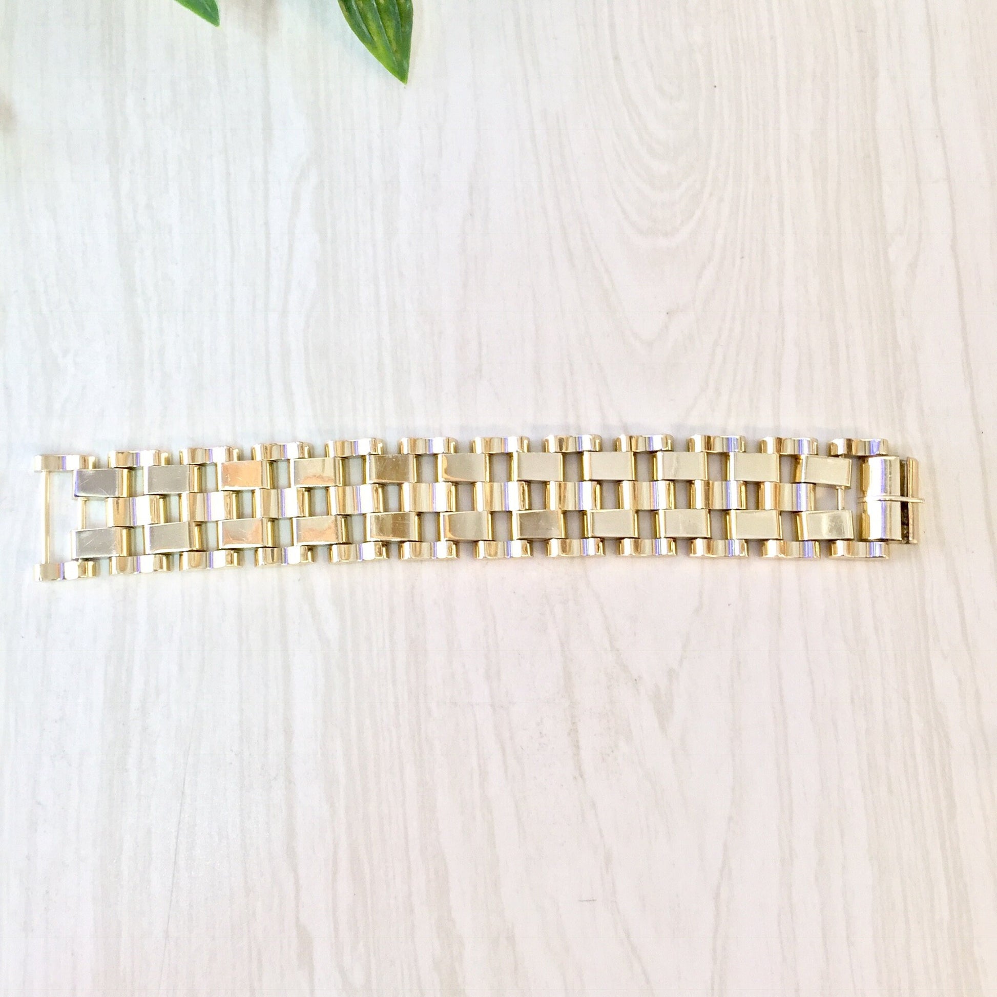 Vintage gold-toned chunky chain link bracelet on wooden surface with leaves, suitable as gift for mom or vintage jewelry enthusiast.