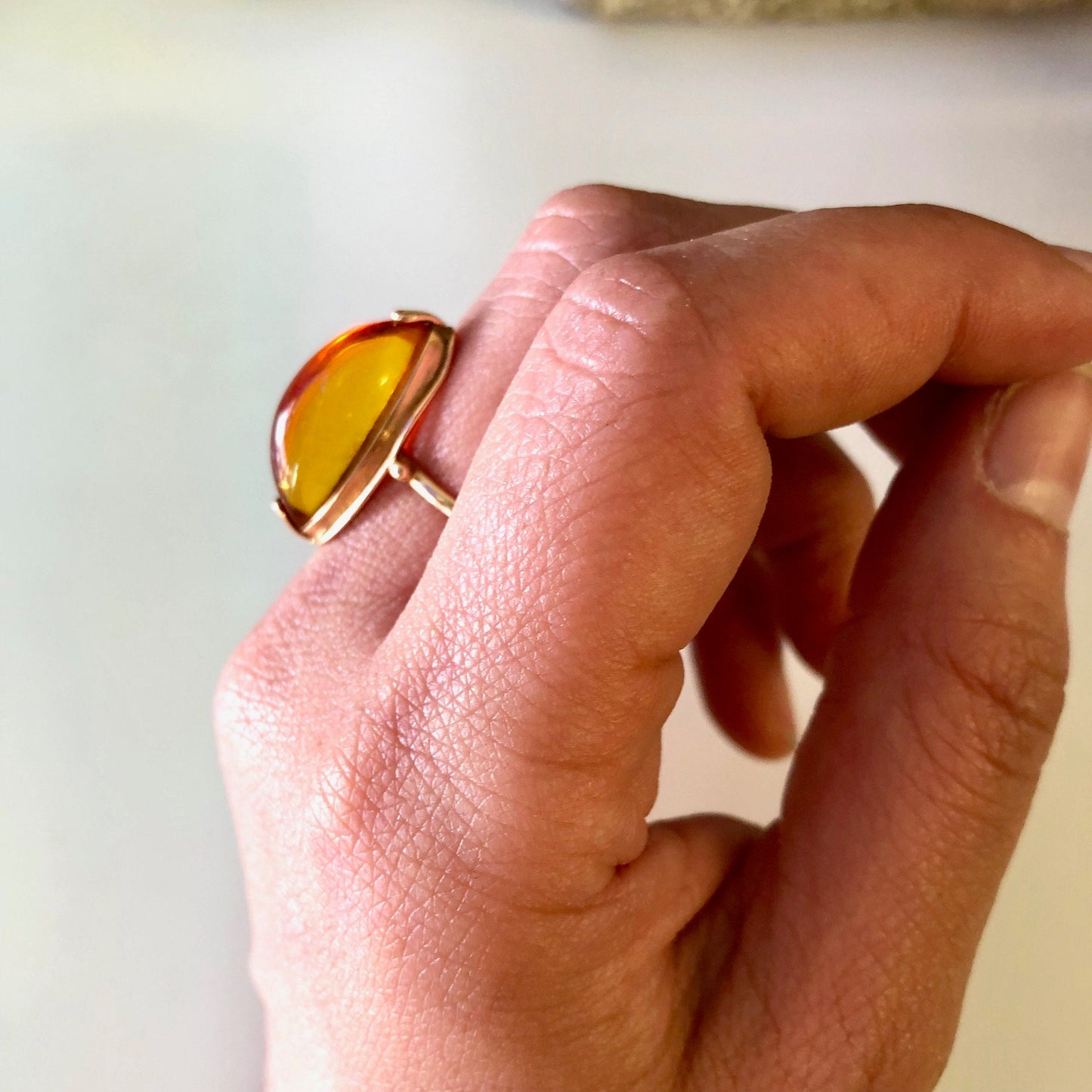 Vintage 10K yellow gold ring with an amber stone, held between fingers showing detail of the jewelry piece.