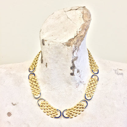 Vintage gold tone chain link statement necklace with dark blue accents, displayed on white rock - elegant gift idea for mom or unique vintage jewelry piece.