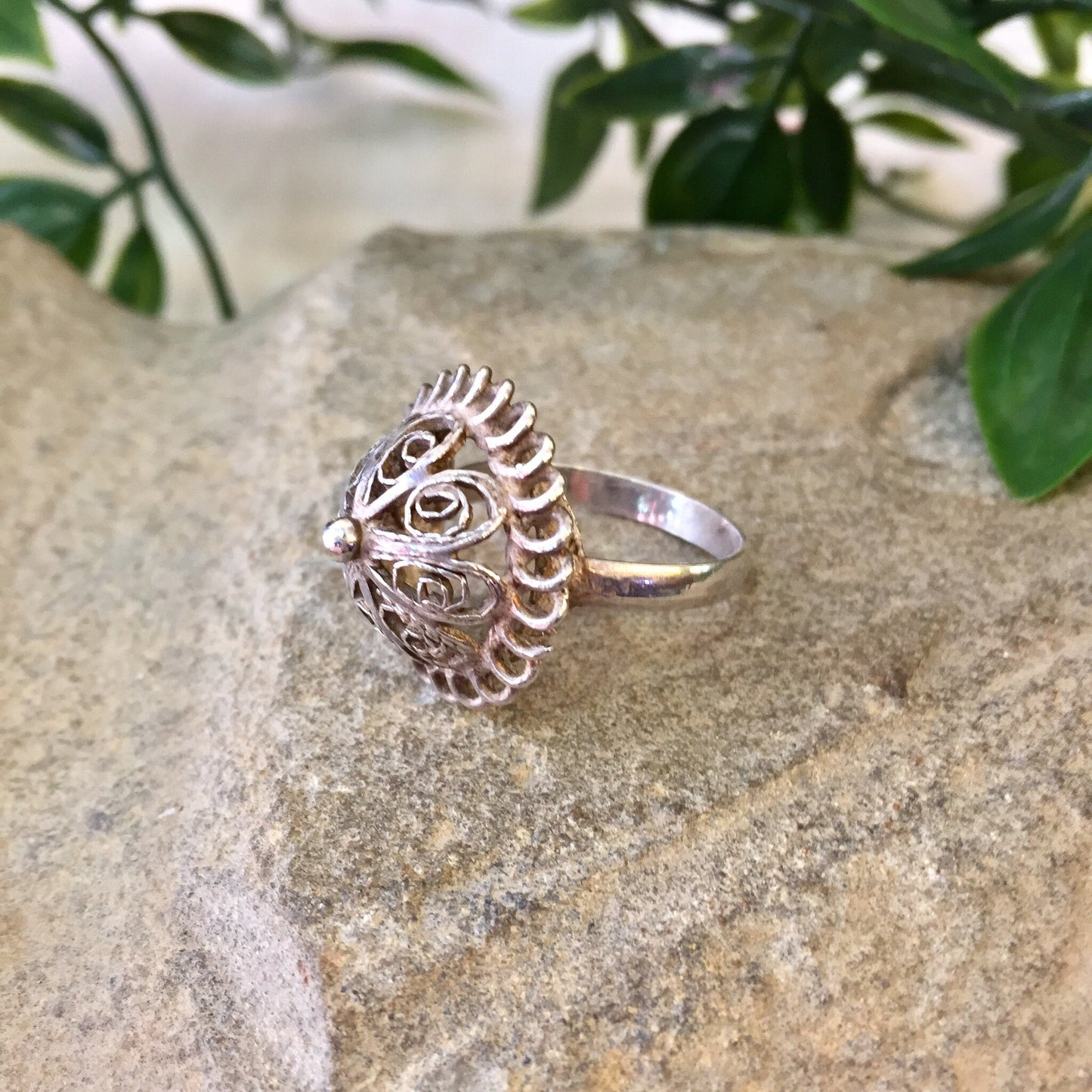 Vintage sterling silver dome ring with intricate cutout design, displayed on stone surface with greenery in background, perfect for wedding jewelry or Mother's Day gift.