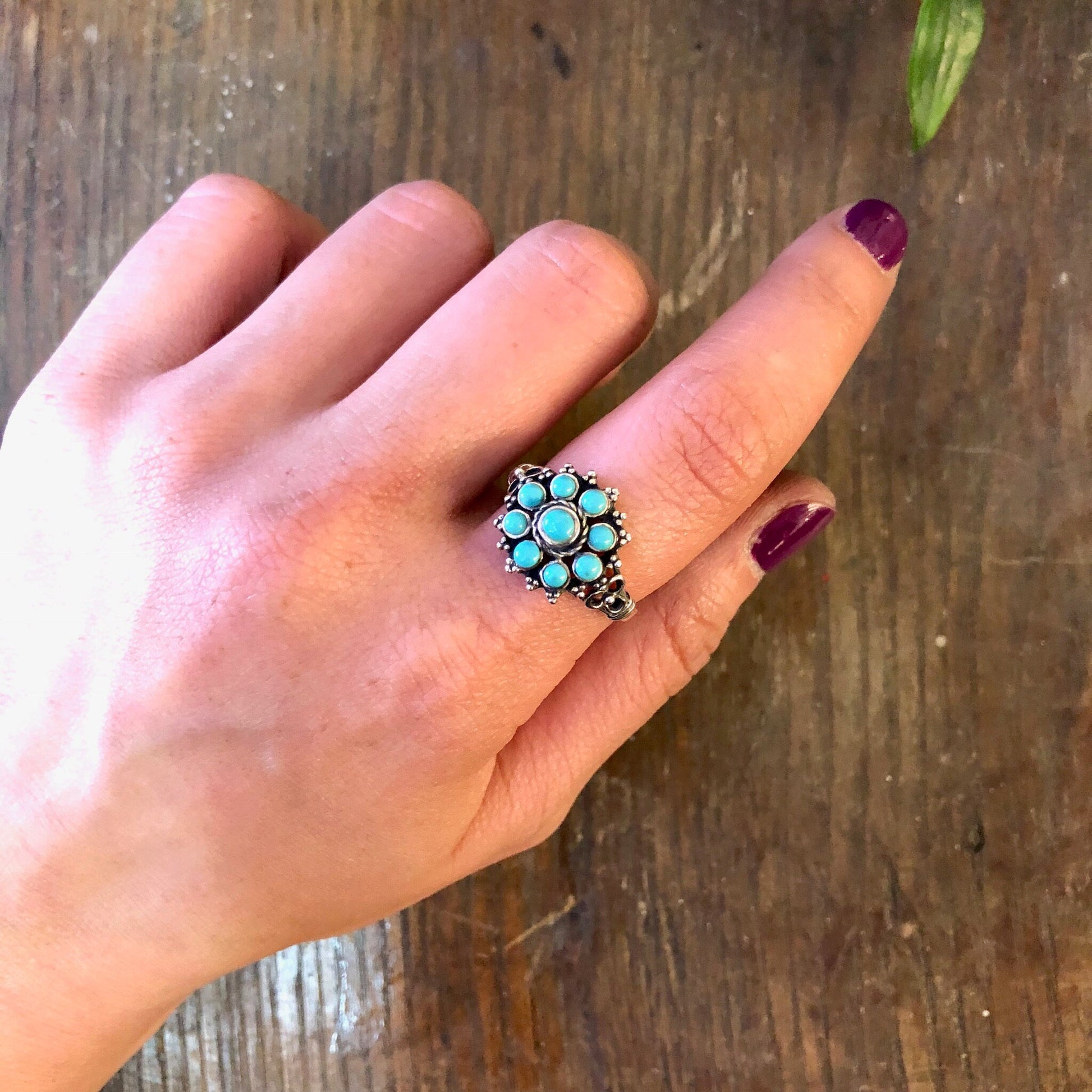 Vintage sterling silver ring with turquoise beads on a wooden surface, bohemian jewelry