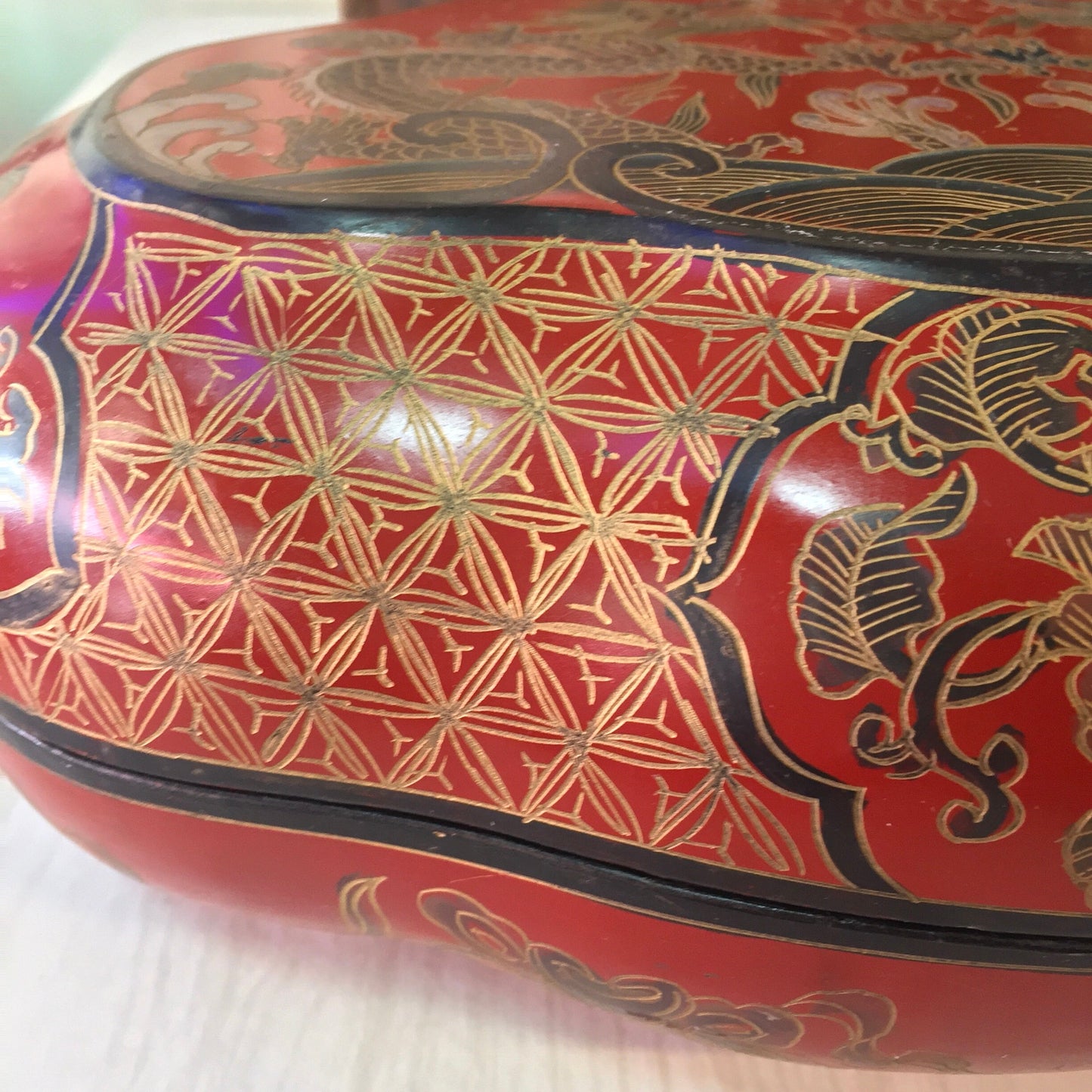 Vintage red Asian laminated box with intricate gold and blue dragon and geometric pattern design, lidded trinket or jewelry box for storage or gift giving