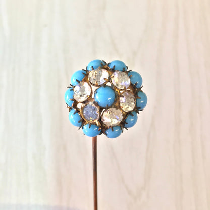 Vintage blue and yellow gemstone cluster hat pin against a plain background