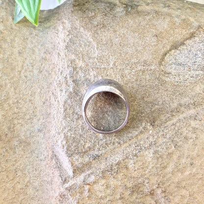 Vintage silver textured pinky ring on stone background