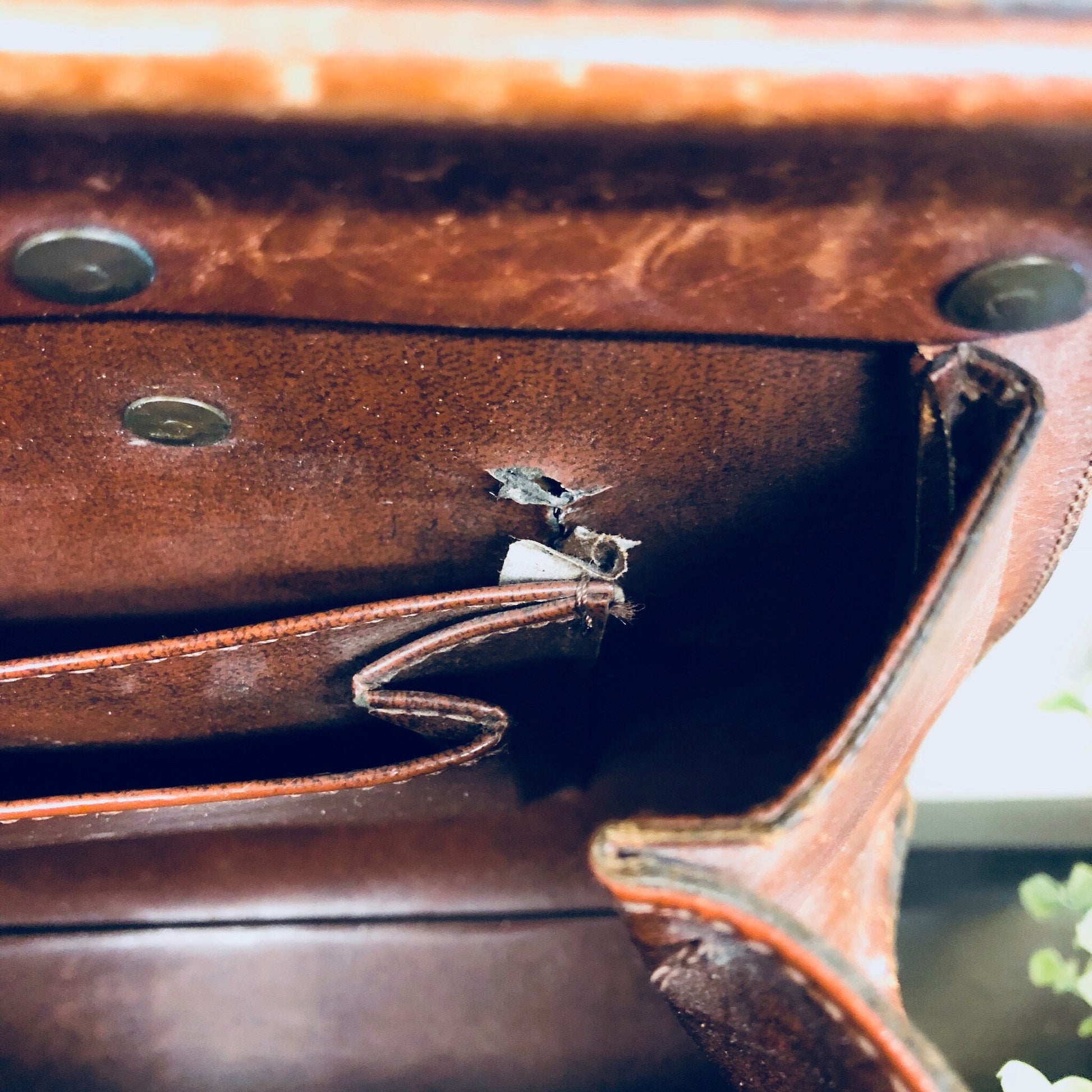 Vintage brown leather handbag with metal studs and detailing, creating a bohemian, rustic style purse reminiscent of 1960s boho chic fashion.