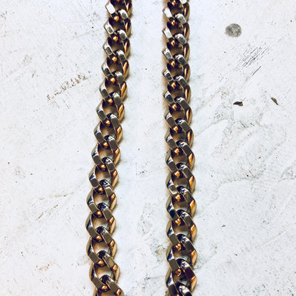 Vintage gold-toned thick chain necklace by Monet jewelry featuring interlocking oval links, creating a bold statement pendant design against a textured concrete background.