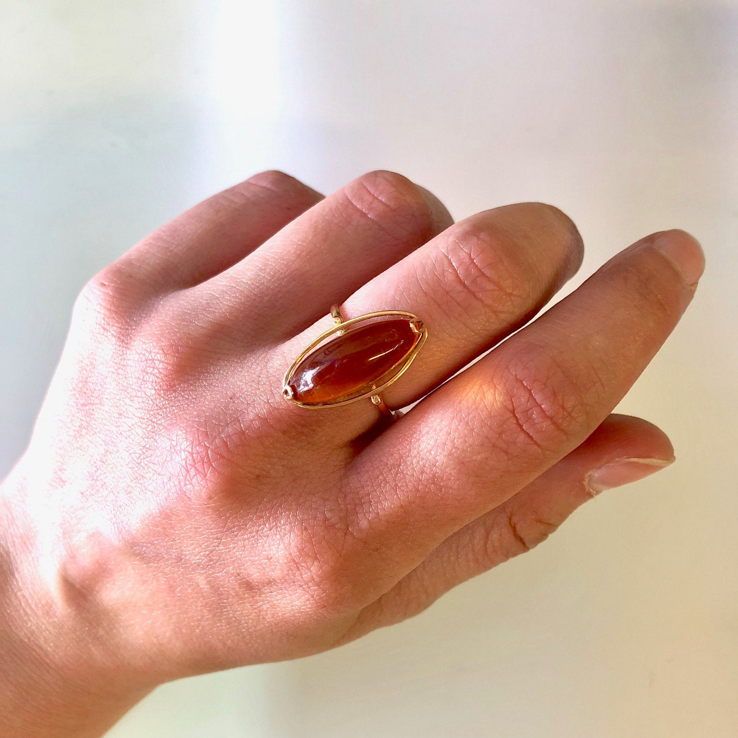 Vintage 10K yellow gold ring with an amber stone, shown on a hand against a plain background.