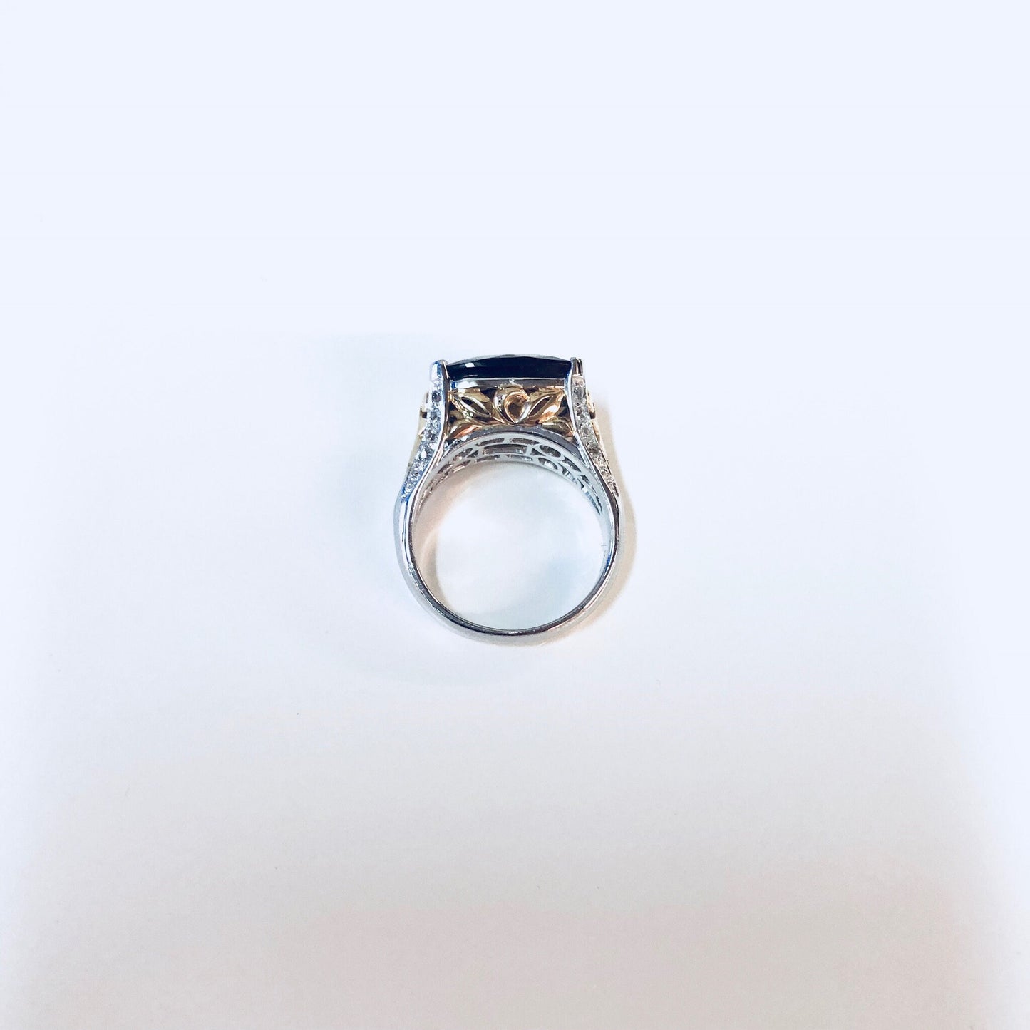 Vintage silver cocktail ring with blue topaz or cubic zirconia stone and intricate detailing on the band, photographed on a plain white background