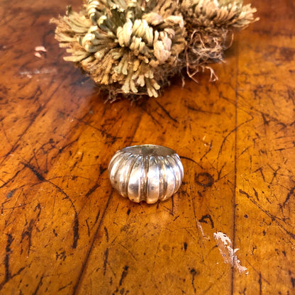 Vintage sterling silver ridged statement ring on weathered wooden surface with dried flowers