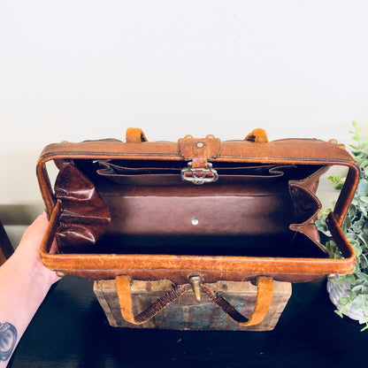 Brown leather vintage handbag with rustic bohemian style from the 1960s, opened to show interior compartments