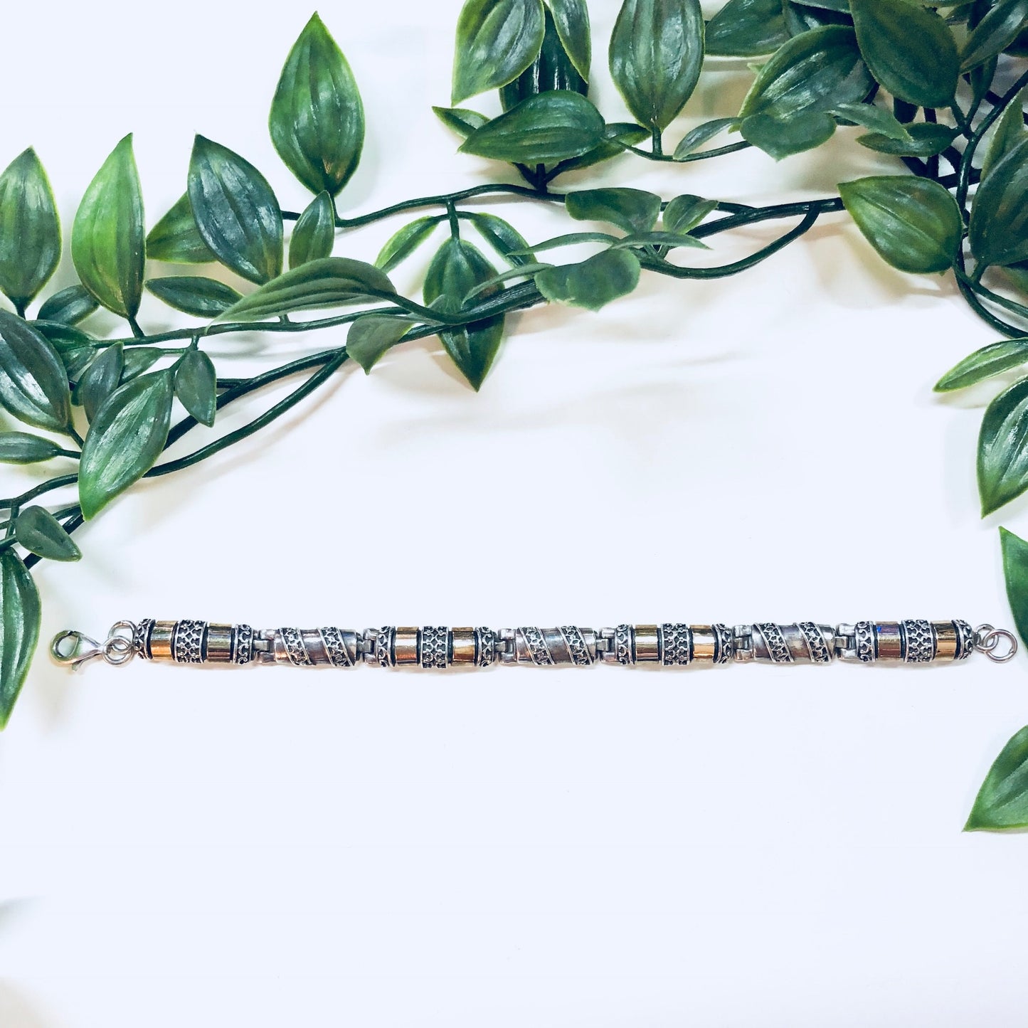 Vintage sterling silver and gold inlay link bracelet with 925 stamp, displayed on a white background with green foliage, perfect for an anniversary gift.