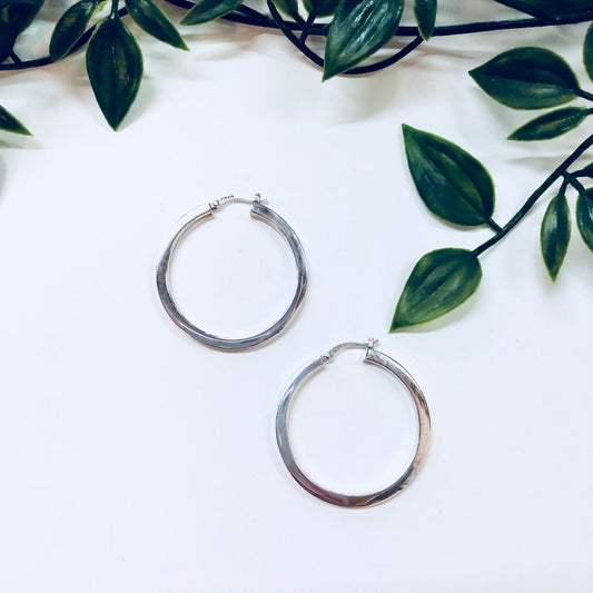 Vintage sterling silver small hoop earrings on white background with green leaves, 925 stamped, 90s fashion style pierced simple jewelry.