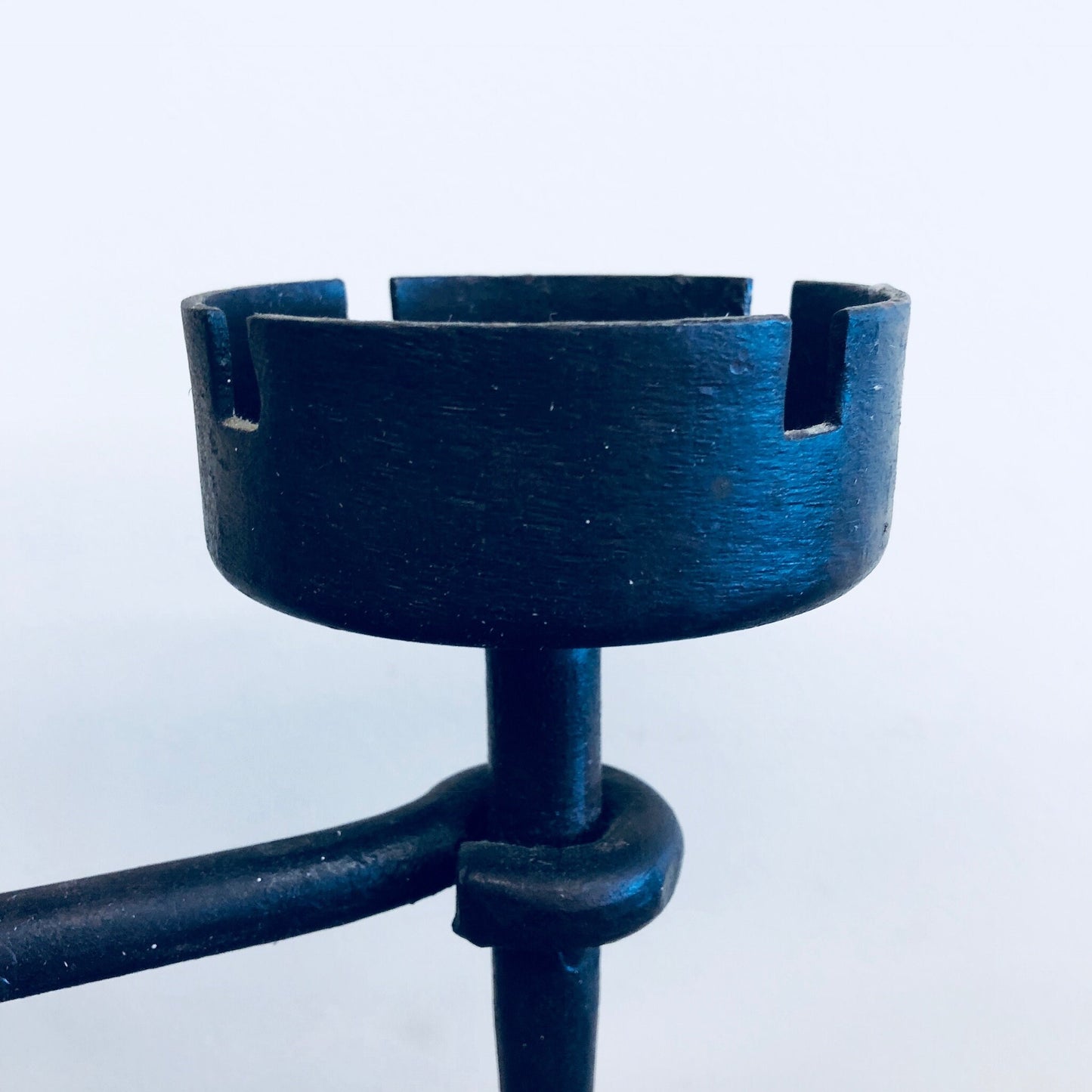 Wrought iron candle holder with a blue patina finish, featuring a round open top for holding a candle or serving as an ashtray, mounted on an intricate curved base, suitable as vintage or rustic home decor centerpiece or mantle decoration.