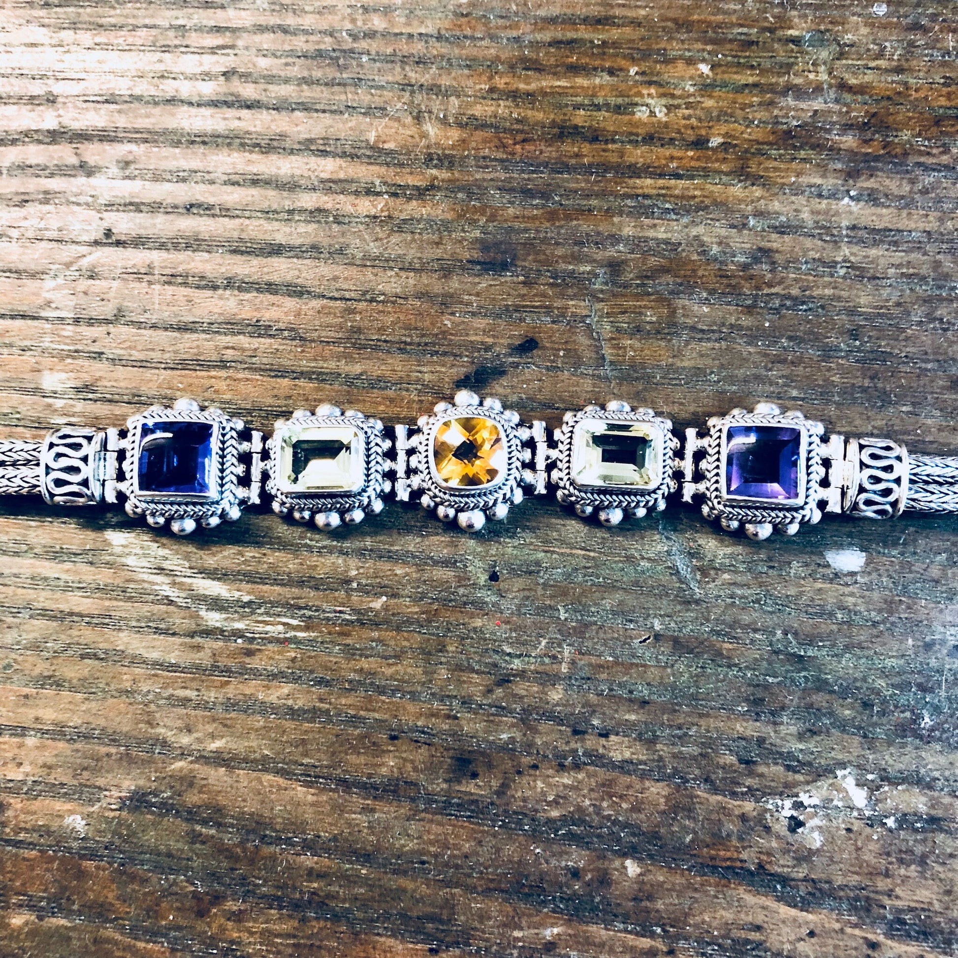 Vintage sterling silver and gemstone link bracelet with amethyst, peridot and citrine stones in purple, green and yellow hues, made by Suarti BA.