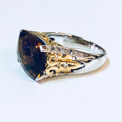 Vintage silver cocktail ring with blue topaz and cubic zirconia accents in a gold filigree setting, perfect as an anniversary gift or statement jewelry piece.