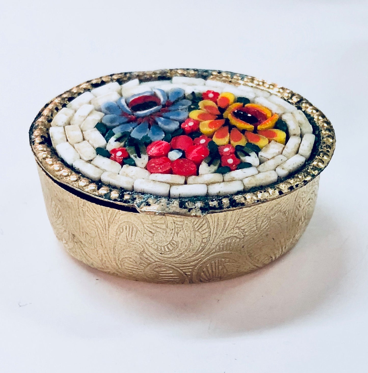 Vintage gold toned pill box featuring a colorful millefiori mosaic design with red, blue, orange and white swirl and paisley patterns, suitable for trinkets or small items.