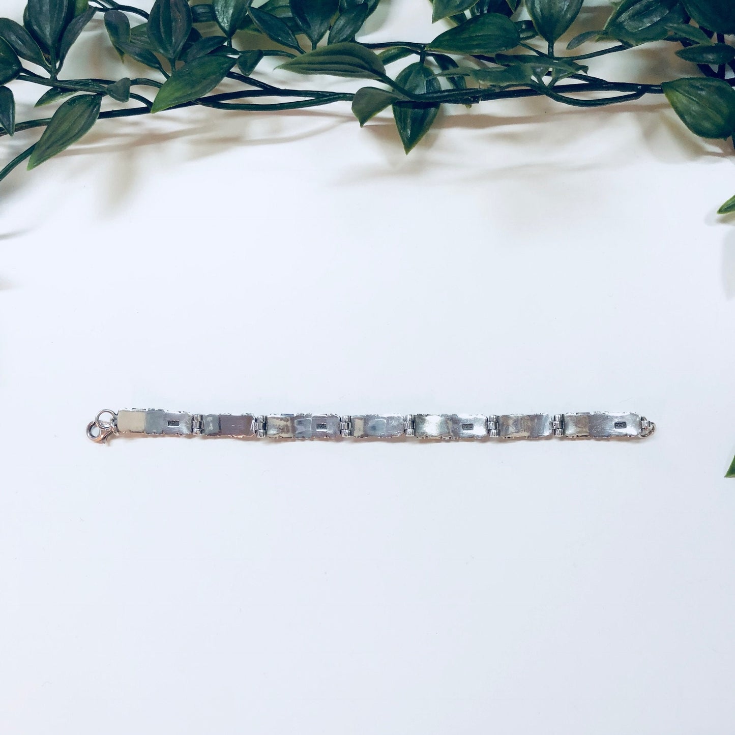 Vintage silver and gold link bracelet with inlay, sterling silver 925, ideal for anniversary gift, displayed against a white background with green foliage.