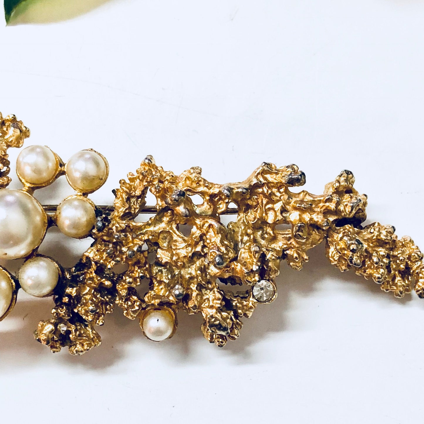 Vintage gold-toned brooch with faux pearls and intricate metalwork design, a large statement costume jewelry pin.