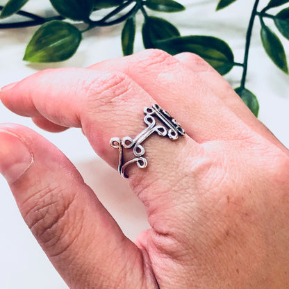 Vintage sterling silver cut out design ring on hand with leaves in background