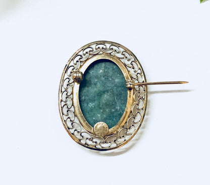 Vintage gold filled brooch with oval green stone and intricate cutout design