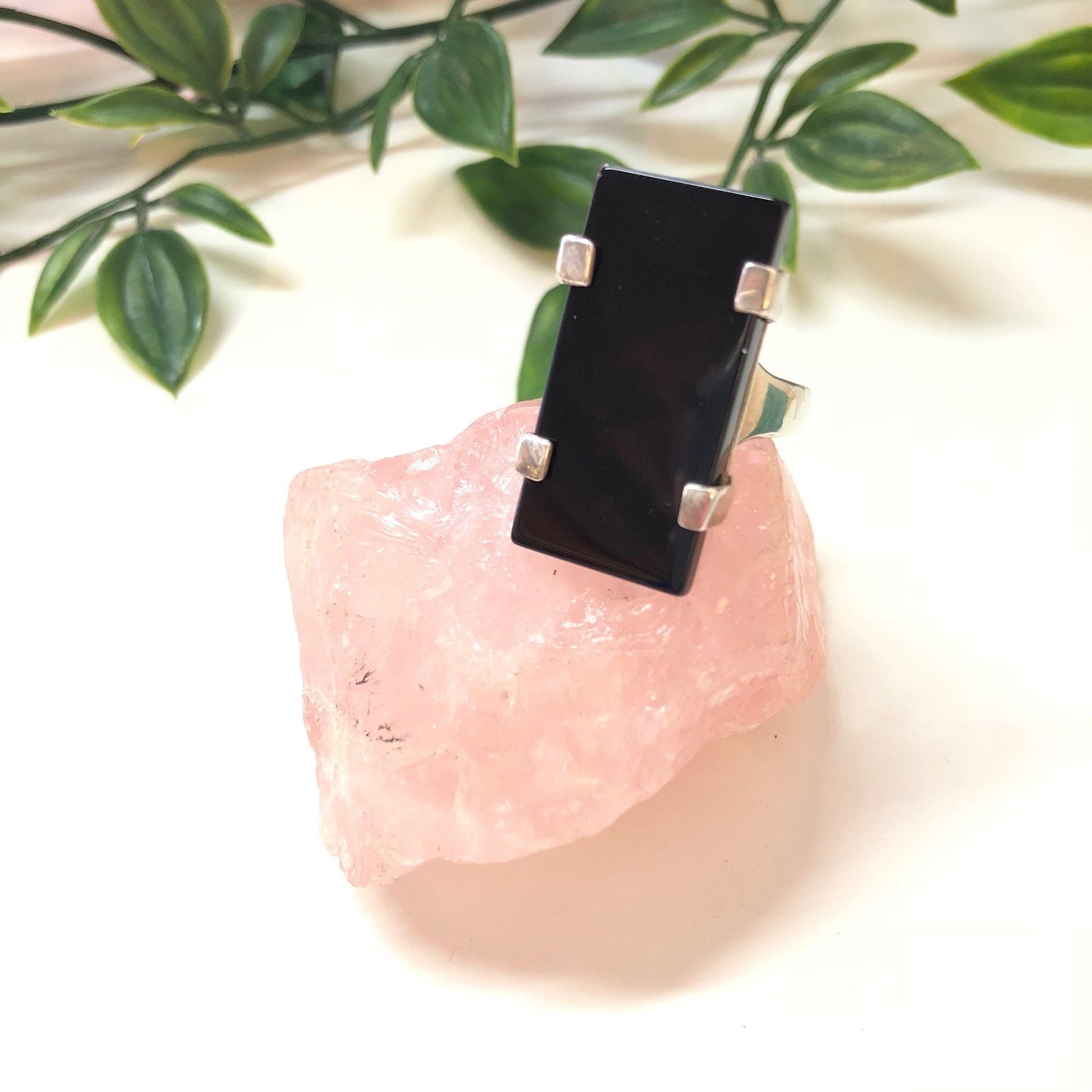 Vintage sterling silver ring with rectangular black onyx stone set on rose quartz crystal, accented by green leaves, minimalist vintage jewelry piece