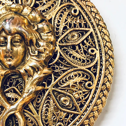 Antique gold locket pendant with intricate filigree detailing and embossed female portrait, vintage jewelry necklace closeup