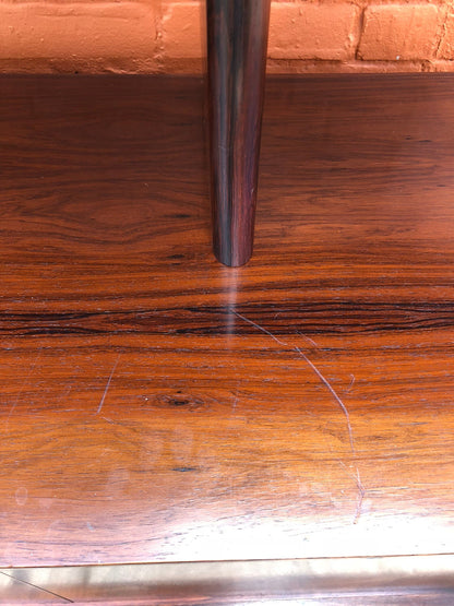 Mid century modern teak wood credenza buffet with tapered legs and intricate wood grain surface scratches and wear, close-up detail view