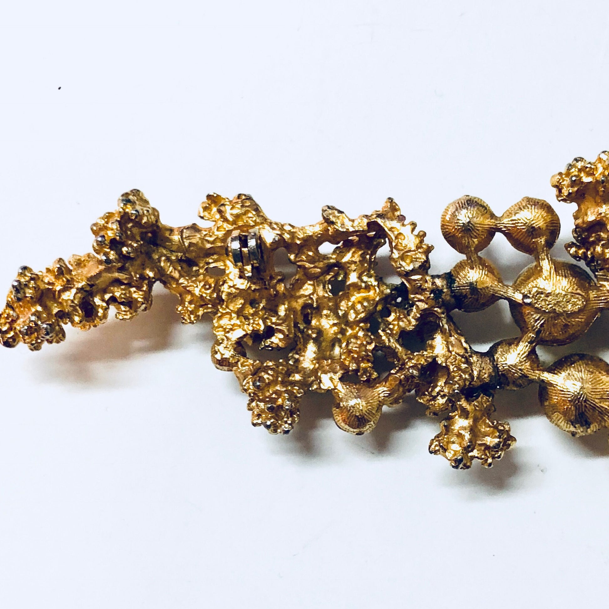 Vintage gold-toned brooch with faux pearls and intricate textured design, suitable as costume jewelry or statement piece.