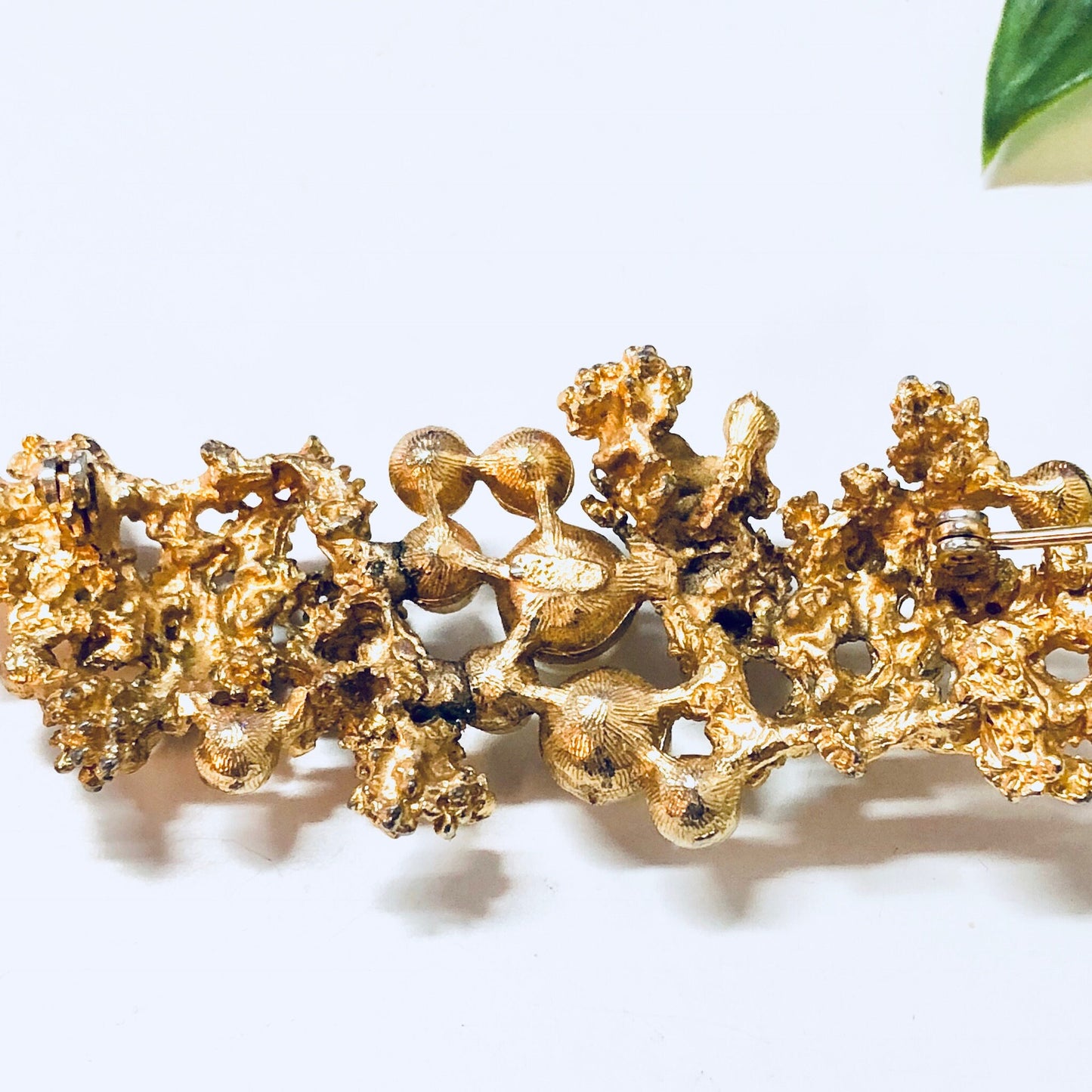 Vintage gold-toned brooch with faux pearls and intricate design, a large statement costume jewelry pin.