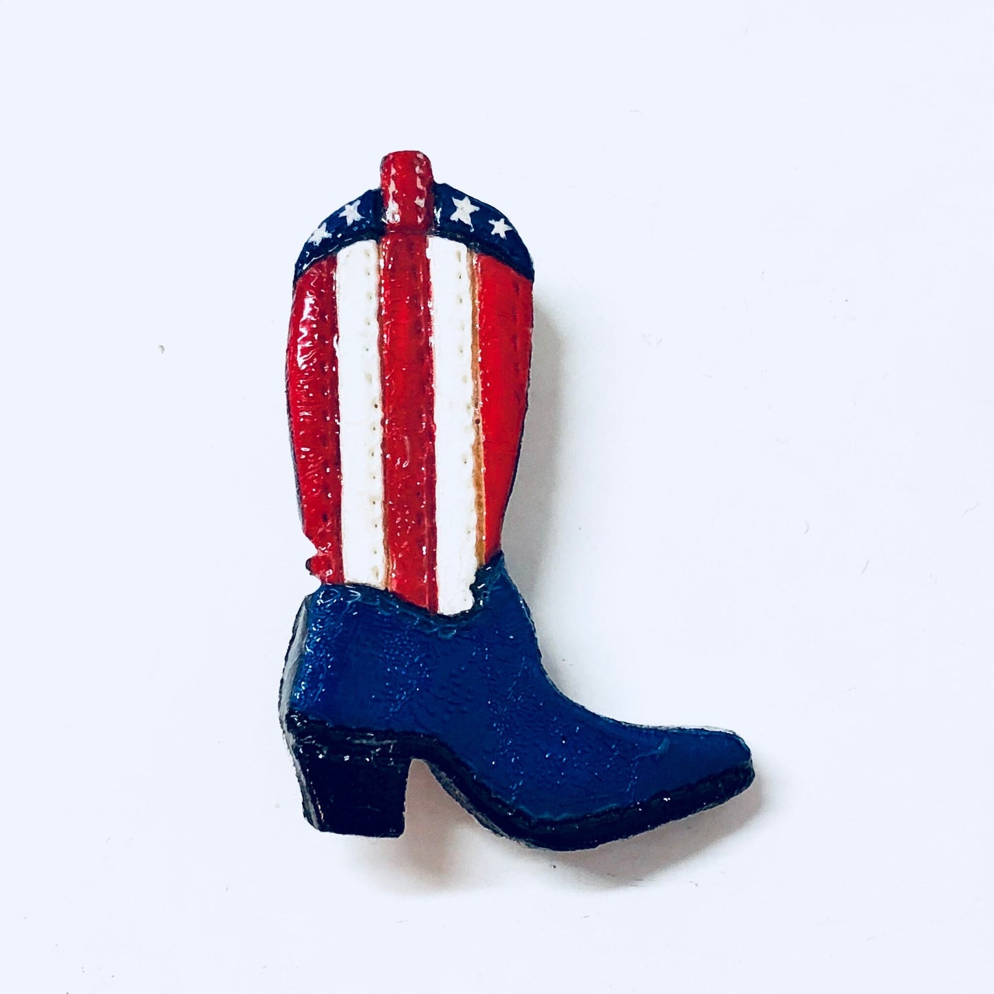 Vintage patriotic American flag cowboy boot pin brooch in red, white and blue colors with star pattern.