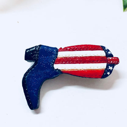 American flag cowboy boot pin brooch in red, white and blue with white stars against a dark blue background, vintage jewelry accessory