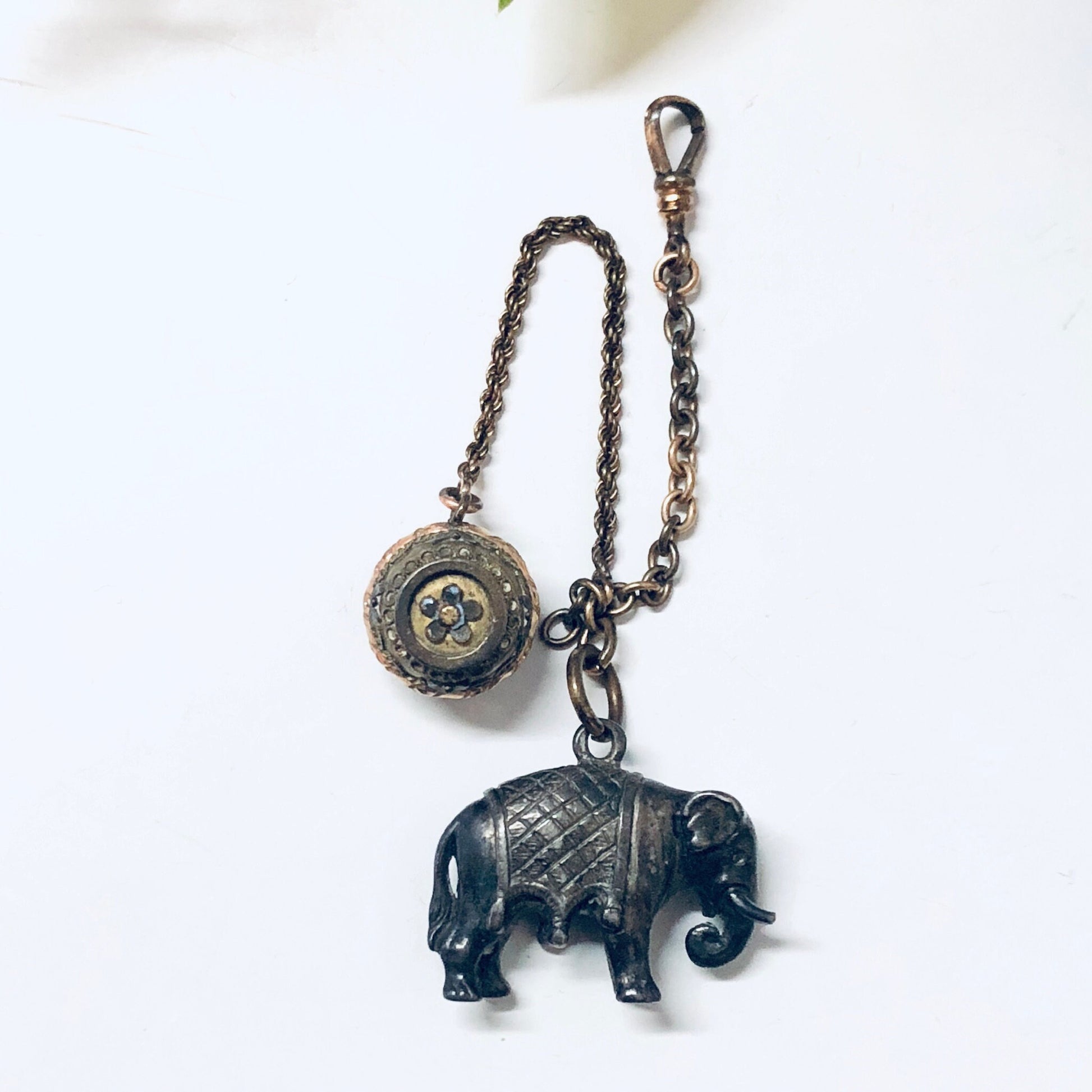 Vintage sterling silver watch fob with engraved elephant pendant and ball charm on antique watch chain