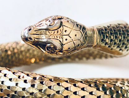 Vintage gold-toned coiled snake mesh bracelet by Whiting and Davis, closeup view on white background