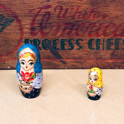 Two hand-painted Russian nesting dolls sit in front of a wooden sign that reads "Function Connection Process Chief" in cursive writing.