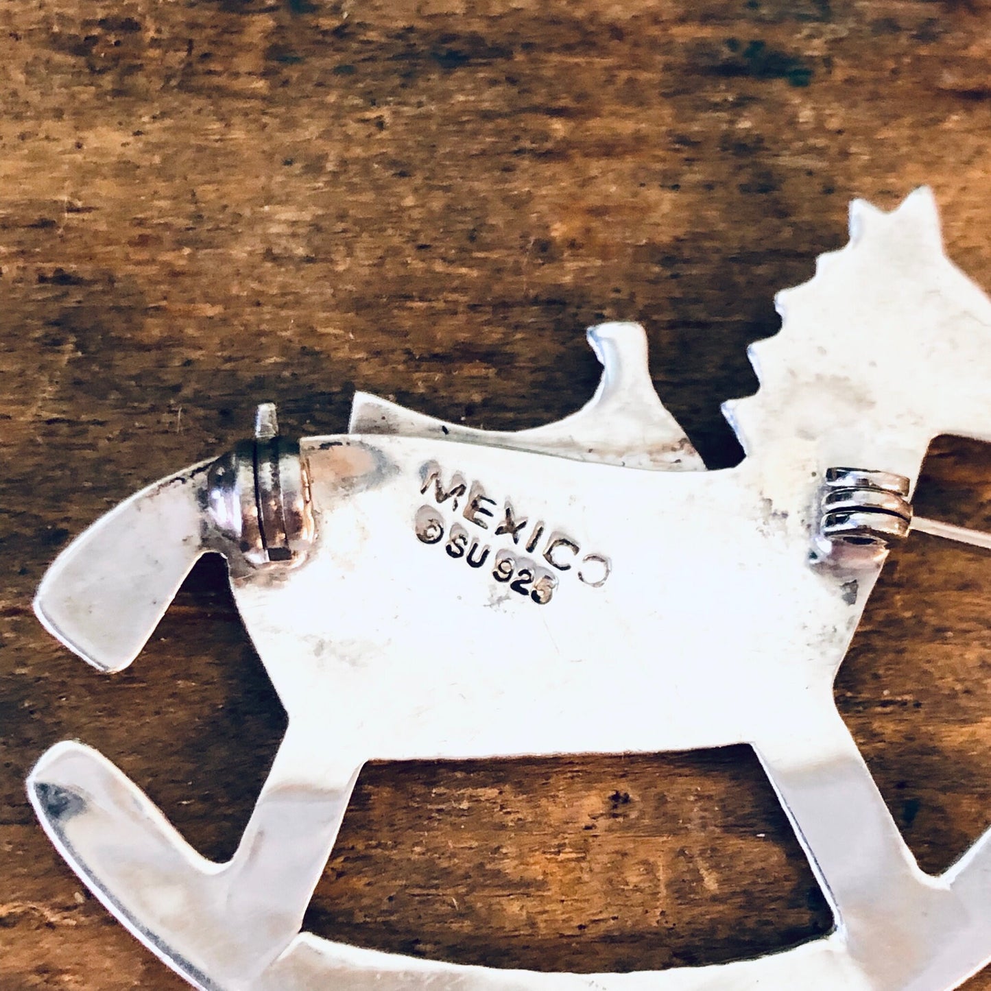 Vintage silver rocking horse brooch, made in Mexico 925 silver, horse-shaped pin jewelry on wooden background, suitable as Valentine's Day gift.