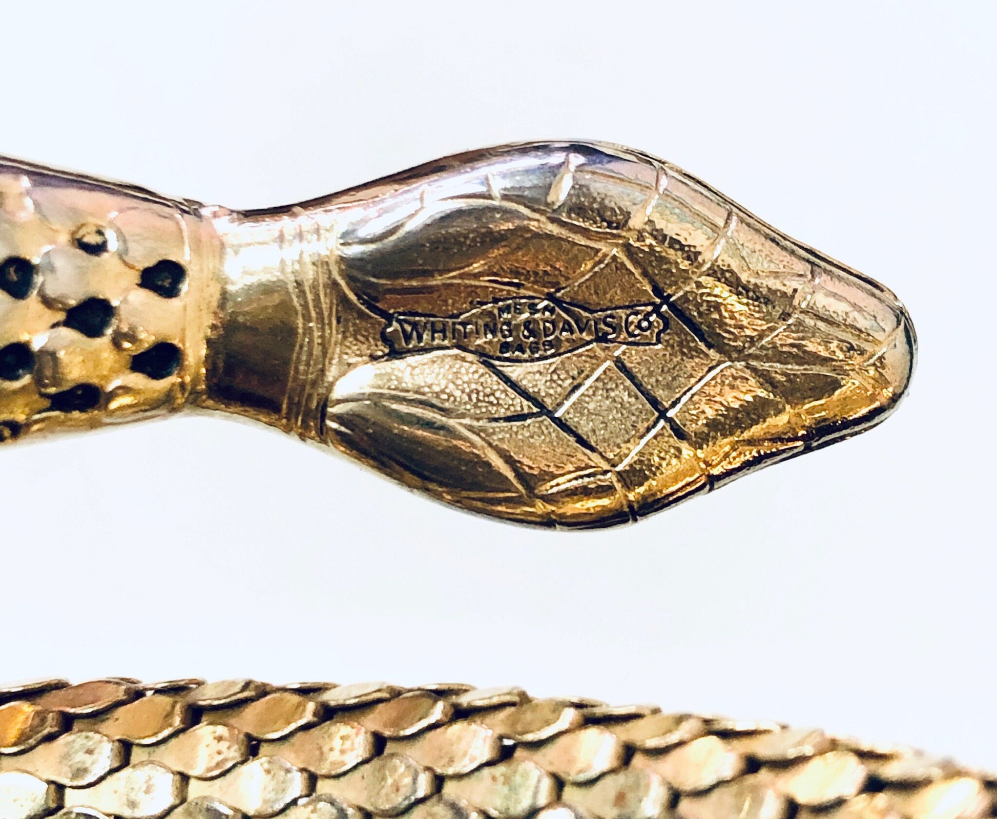 Vintage gold-toned Whiting and Davis mesh snake bracelet, coiled design, detailed closeup view on white background