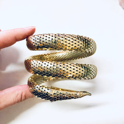 Vintage gold-toned mesh snake bracelet coiled around fingers, featuring intricate scaled pattern, by Whiting and Davis.