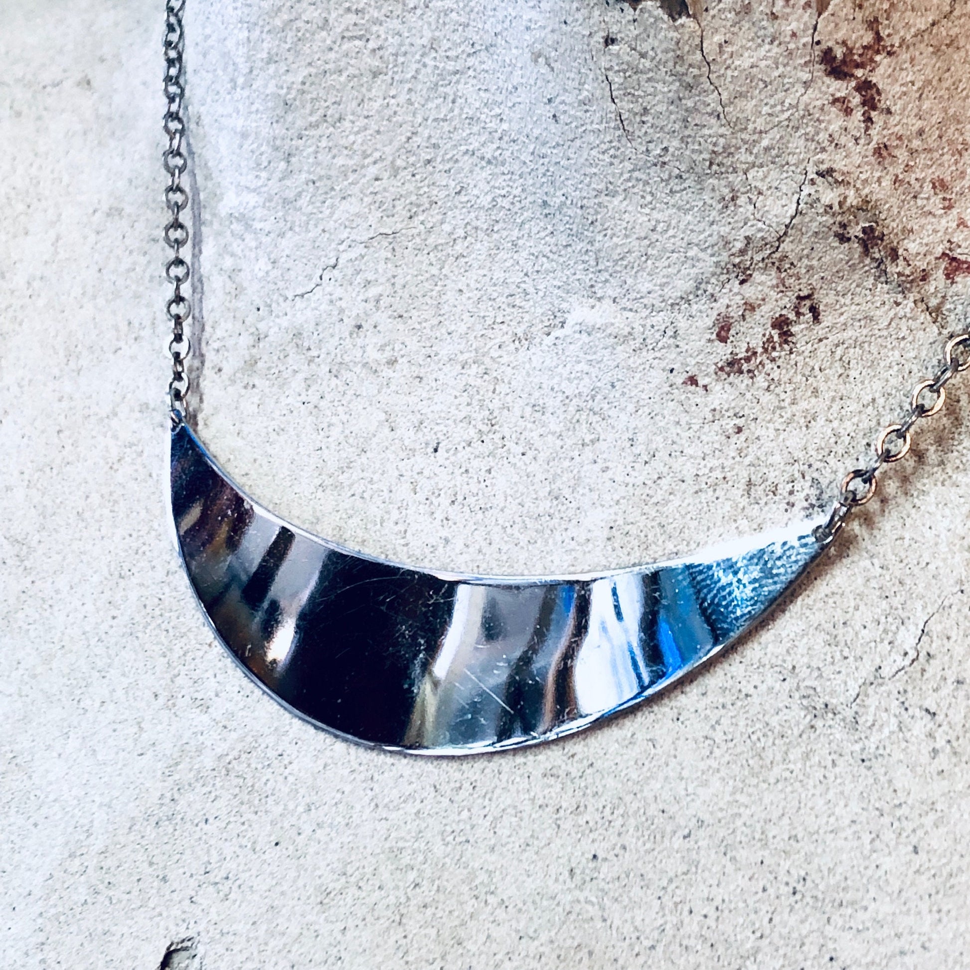 Vintage Danecraft silver necklace with a sleek, minimalist panel pendant design, photographed on a textured stone surface.