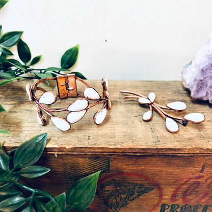 Vintage Matisse copper and white enamel jewelry set on wooden table with greenery