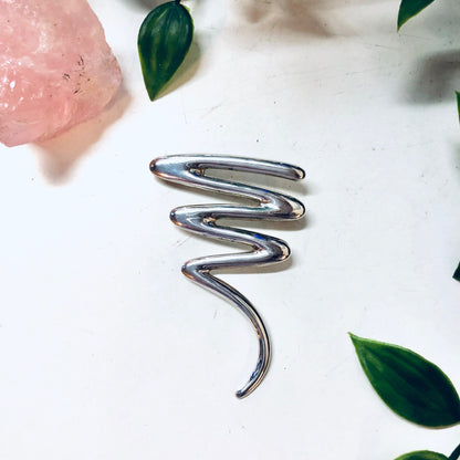 Vintage sterling silver abstract squiggle brooch pin, line design jewelry for Valentines Day gift, with pink flowers and green leaves on white background.