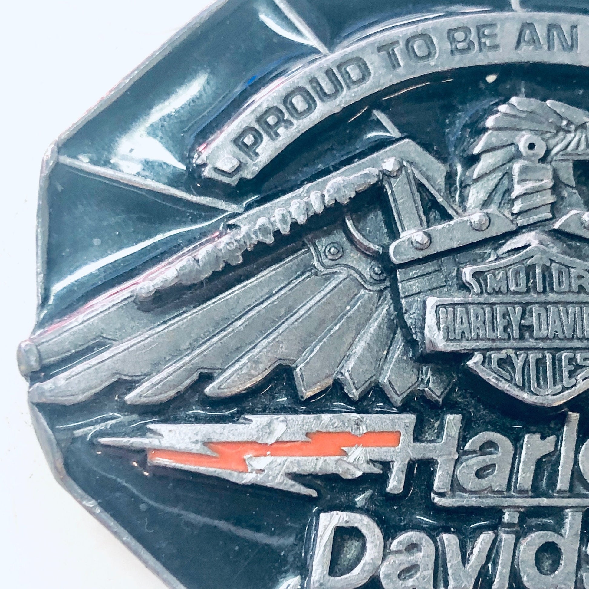 Vintage Harley Davidson belt buckle featuring an eagle design and "Proud to be an American" text, collectible biker accessory and gear.