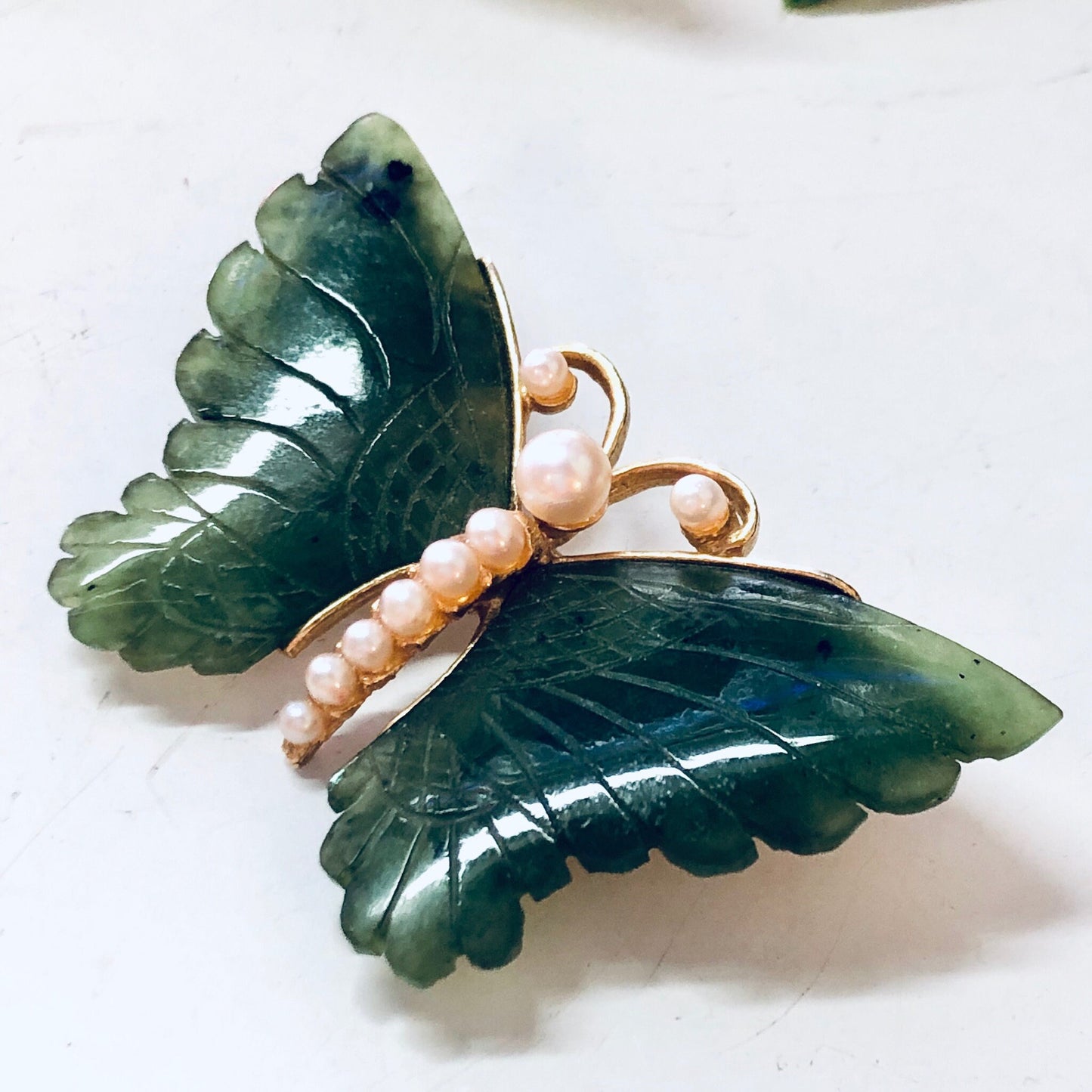 Vintage green jade butterfly brooch with faux pearls and gold-tone metal, elegant pin for adding a touch of nature-inspired beauty to any outfit.