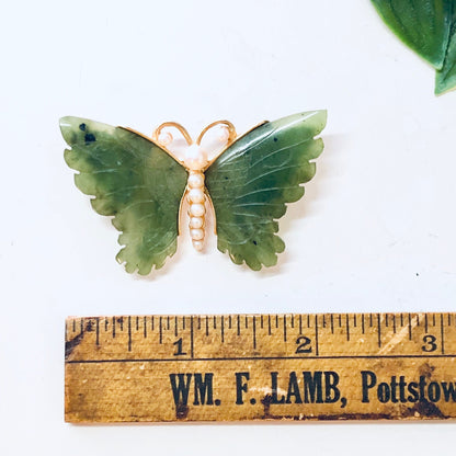 Vintage gold-toned butterfly brooch with faux pearl body and green jade wings, shown on a wooden ruler with "WM. F. LAMB, Pottstown" label.