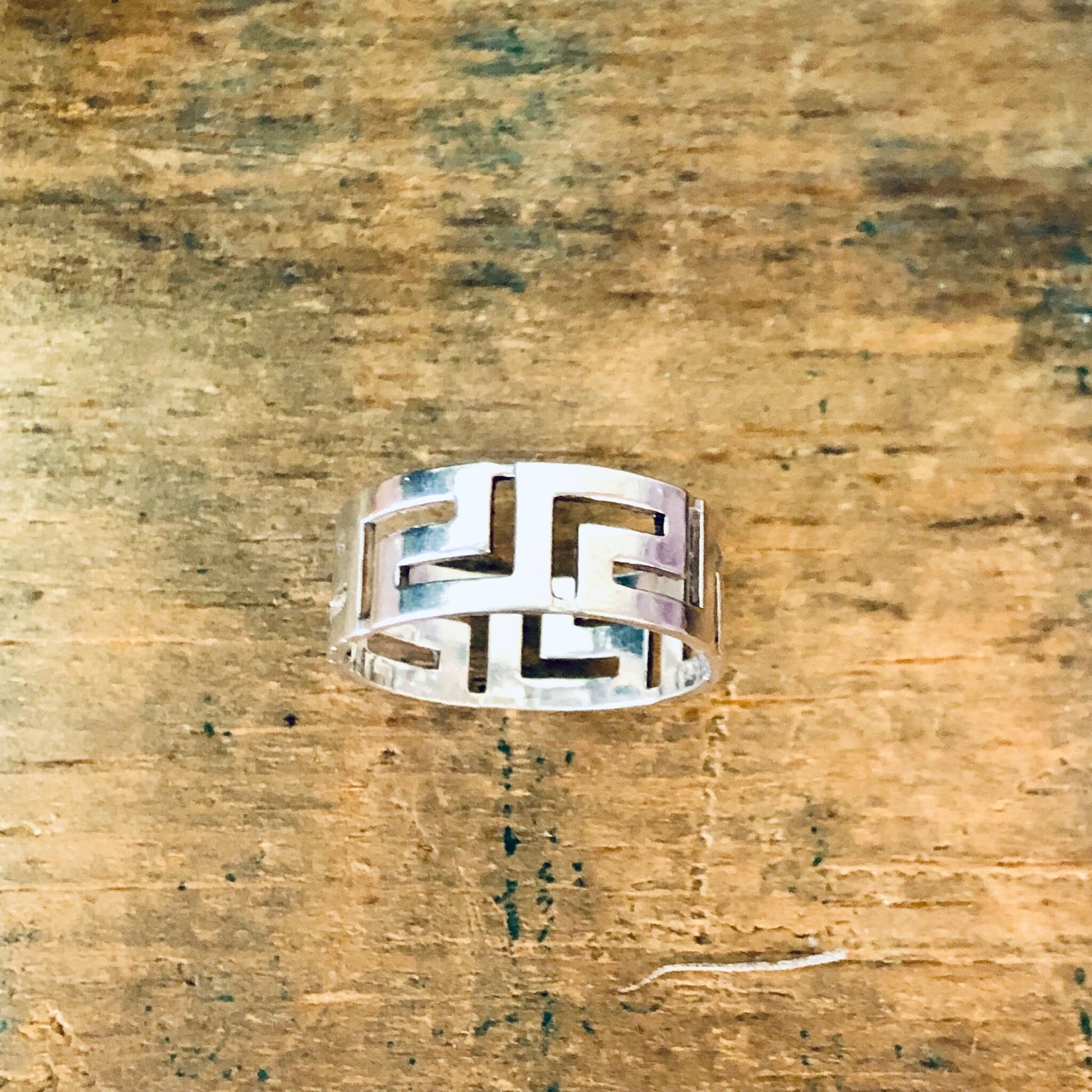 Vintage sterling silver cutout ring with unique minimal geometric design on rustic wooden surface