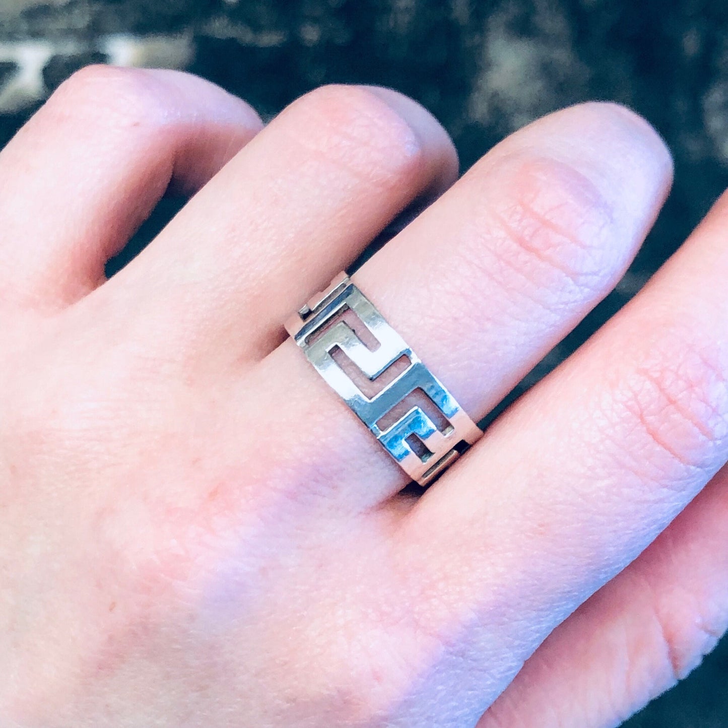 Vintage sterling silver cut-out band ring with minimal design on finger