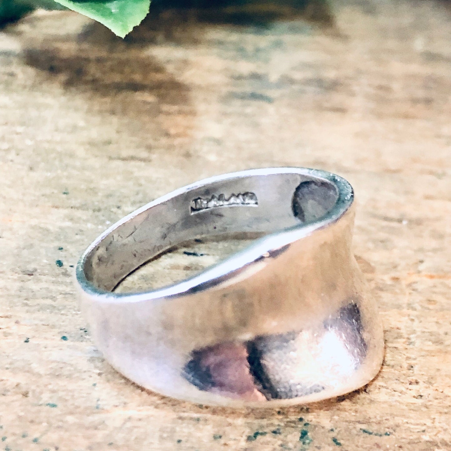 Vintage silver band ring with an abstract, minimalist design on a rustic background