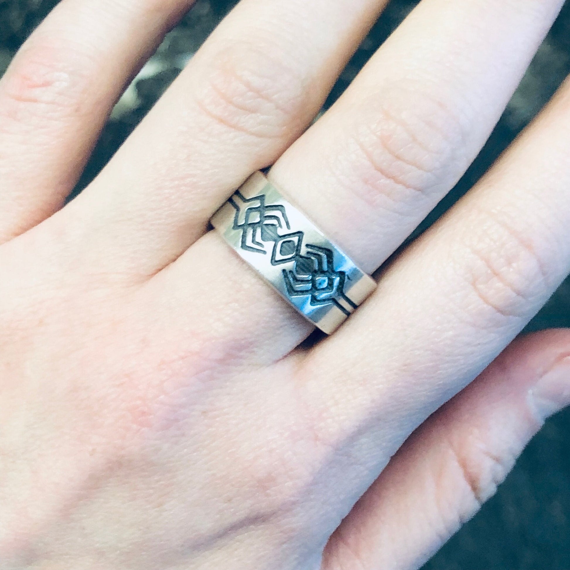 Vintage silver geometric tribal design thick band ring on person's finger