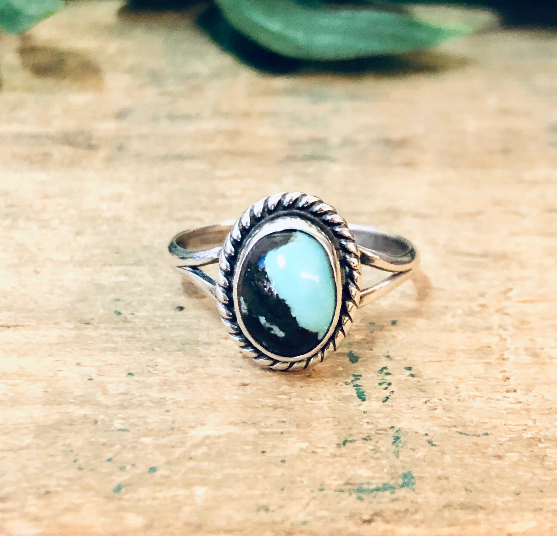 Vintage silver ring with blue and brown stone cabochon setting on weathered wood surface