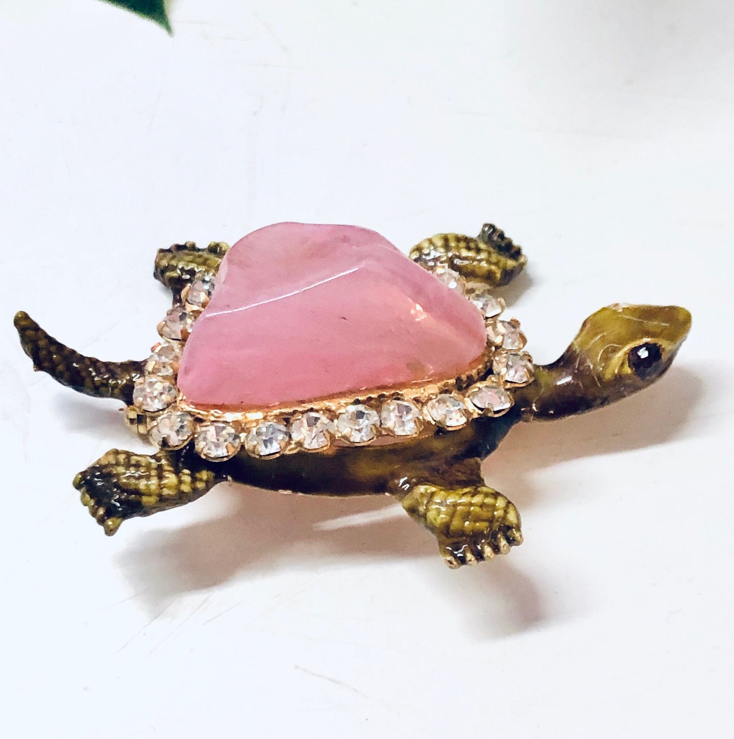 Vintage gold-toned turtle pin brooch with pink gemstone shell and rhinestone details on a white background.