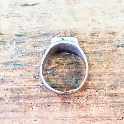 Vintage silver cocktail ring with raw quartz stone on weathered wooden surface